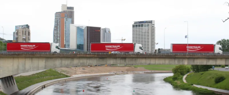 ثلاث شاحنات HT Logistics مع نصف مقطورات Hanse Trailer على جسر في فيلنيوس