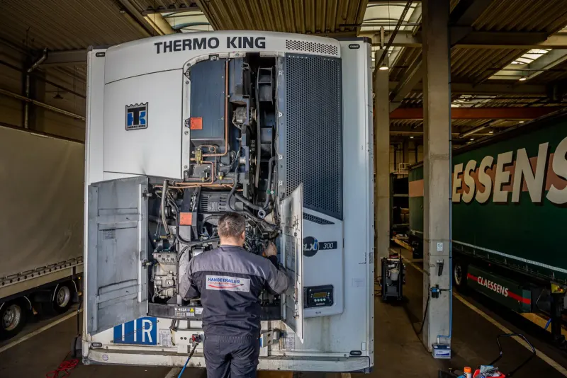 Ein Techniker wartet ein Thermo-King-Kühlaggregat an einem Auflieger