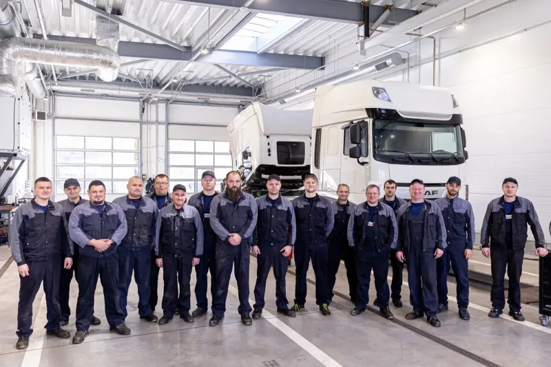 Das HTL-Werkstattteam in Arbeitskleidung in der Werkstatthalle